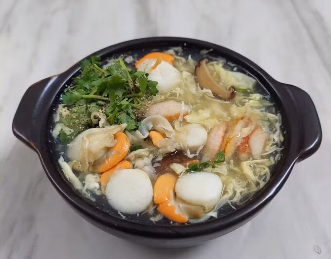 Súp cua ở Xí Muội Quán trong hẻm nhỏ trên đường Bùi Đình Túy, quận Bình Thạnh bắt đầu mở bán lại từ ngày 18/9, trên các app đặt thức ăn, hơn 1.000 người dùng đánh giá 4,7/5 về chất lượng món ăn tại đây. Súp cua vừa miệng, nhiều nguyên liệu, có độ sệt vừa phải, phần ăn đóng gói mang về sạch sẽ. Giá mỗi phần chưa tính ship từ 25.000 đến 69.000 đồng cho các món súp cua thường, súp cua mực, súp cua óc heo, trứng bách thảo, hàu sữa, tôm, trứng gà non, bào ngư... Ảnh: Xí Muội Quán