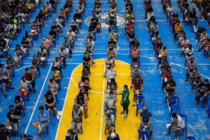 Người dân ở Manila xếp hàng chờ tiêm vaccine Moderna. Ảnh: Reuters