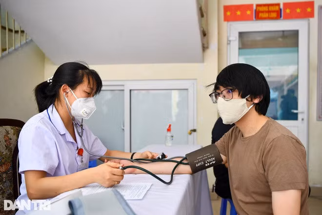Đo huyết áp cho người được tiêm vắc xin Covid-19.