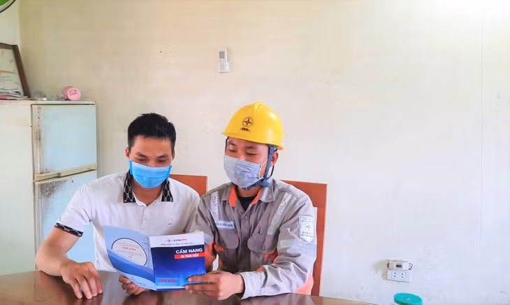 Nhân viên Điện lực Quảng Ninh tuyên truyền an toàn điện đến người dân.