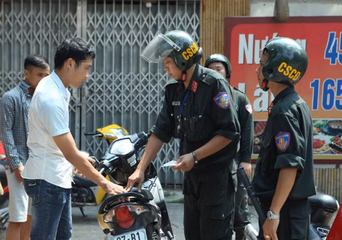 Cảnh sát xử phạt người đi xe máy không đội mũ bảo hiểm ở Hà Nội. Ảnh: Phương Sơn