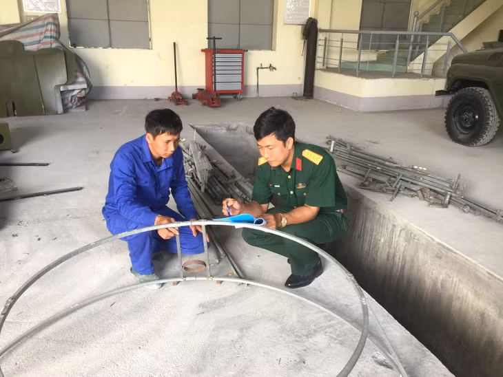 Thiếu tá Vũ Văn Nhất (bên phải) hướng dẫn triển khai các sáng kiến cải tiến kỹ thuật tại đơn vị.