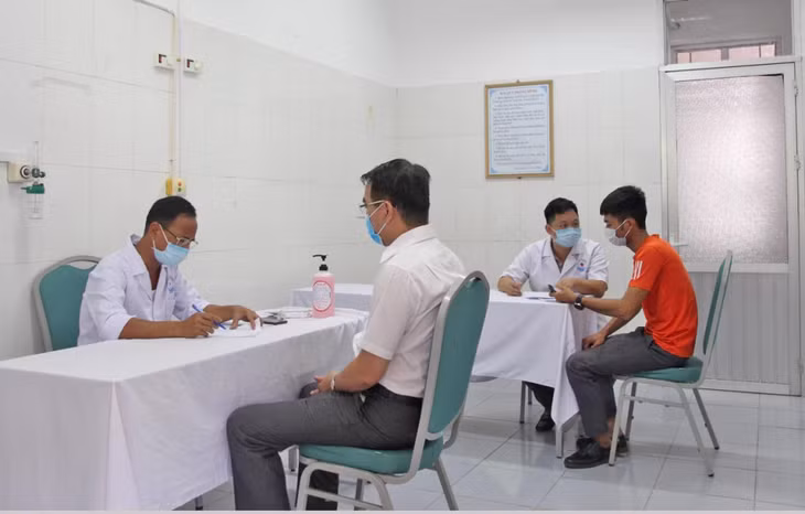 Cán bộ Trung tâm Y tế huyện Vân Đồn khám sàng lọc trước khi tiêm vắc xin phòng Covid-19 cho người dân.