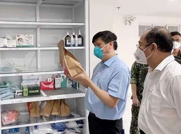 Bộ trưởng Bộ Y tế Nguyễn Thanh Long kiểm tra túi thuốc hỗ trợ điều trị cho F0 tại nhà. (Ảnh: TTXVN phát)