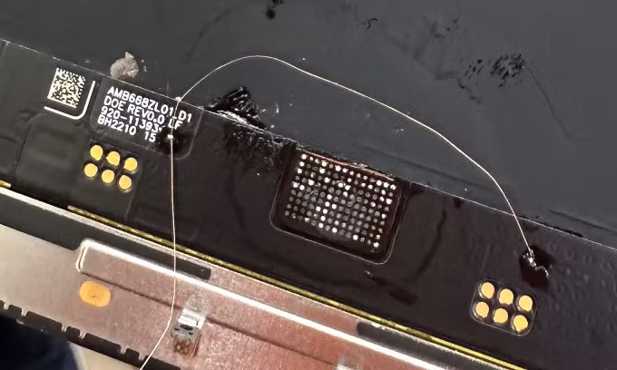 Sợi dây đồng được hàn vào bảng mạch giúp màn hình iPhone 13 Pro Max hoạt động trở lại, sau đó được dán kín để bảo vệ. Ảnh: Quân Ngô