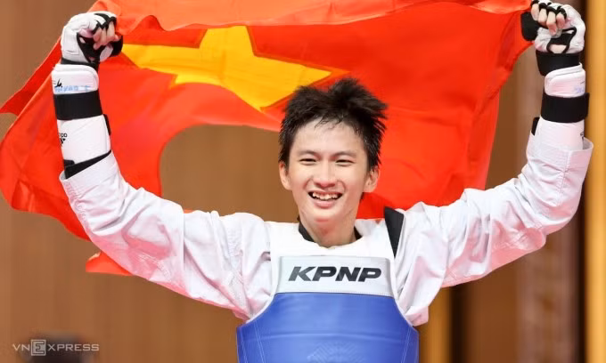 Võ sĩ taekwondo Phạm Đăng Quang cầm cờ mừng chiến thắng trong trận chung kết hạng 63kg nam. Chiếc HC vàng của anh cũng là HC vàng thứ 120 tròn của đoàn Việt Nam từ đầu SEA Games 32. Ảnh: Hiếu Lương