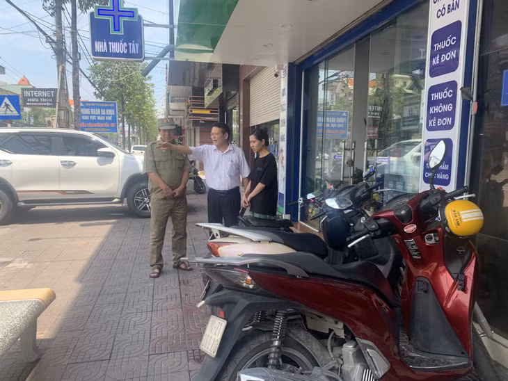 Ông Nguyễn Đình Thảo (giữa) tuyên truyền, nhắc nhở người dân không lấn chiếm vỉa hè, lòng đường.