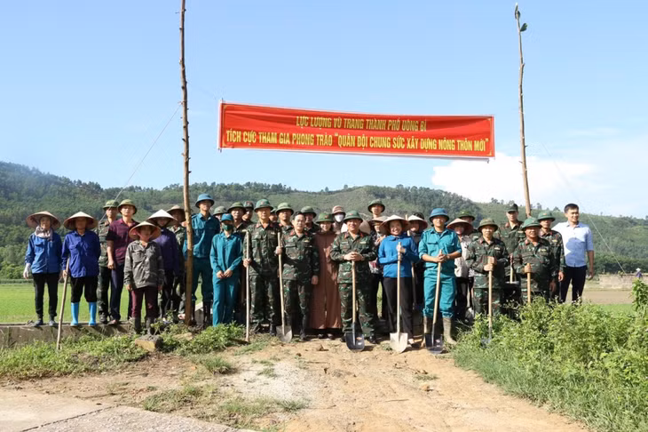 LLVT TP Uông Bí chụp ảnh lưu niệm cùng với nhân dân khi tham gia hỗ trợ địa phương xây dựng NTM.