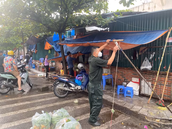 Đội Kiểm tra TTĐT và Môi trường TP Hạ Long thực hiện tháo dỡ các ô dù lấn chiếm trên vỉa hè.