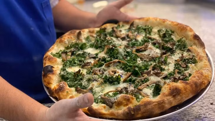 Món pizza cải xoăn và nấm đắt hàng của tiệm Marmellata. Ảnh: CNN
