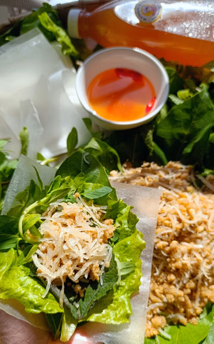 Bì lợn trong như sợi cước, trộn với thính, gói ghém trong tấm bánh đa nem mềm cùng với các loại rau, lá có sẵn trong vườn nhà.