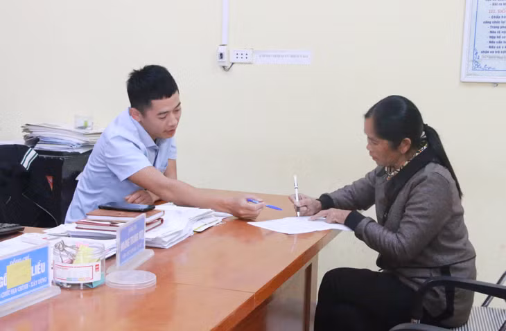 Cán bộ xã Lục Hồn hướng dẫn người dân giải quyết thủ tục hành chính.