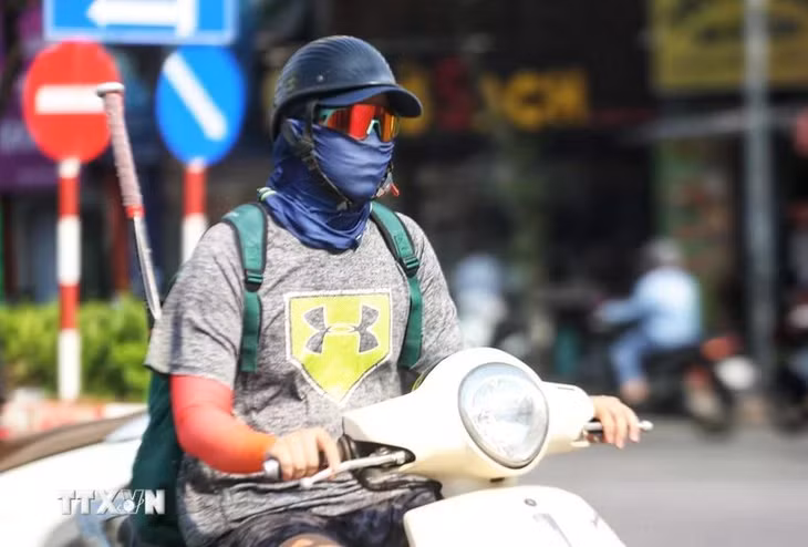 Người dân ra đường ngày nắng nóng thường bịt kín để đảm bảo sức khỏe. (Ảnh: Thu Phương/TTXVN phát)