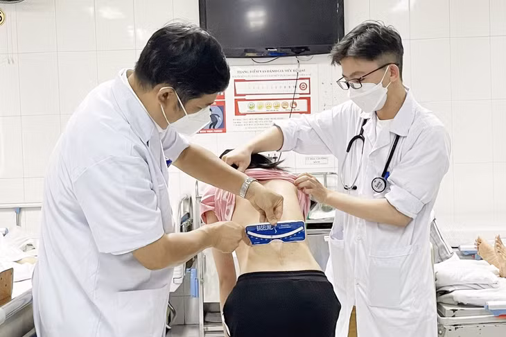 Các bác sĩ Bệnh viện Hữu nghị Việt - Đức kiểm tra cột sống cho một nữ sinh sau phẫu thuật. Ảnh: Xuân Lộc.