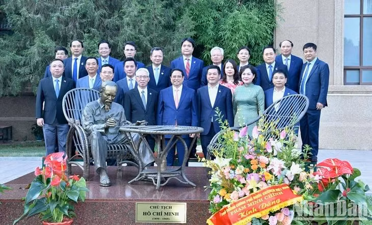 Thủ tướng Phạm Minh Chính và các đồng chí lãnh đạo chụp ảnh lưu niệm bên Tượng đài Chủ tịch Hồ Chí Minh trong khuôn viên Đại sứ quán Việt Nam tại Trung Quốc.