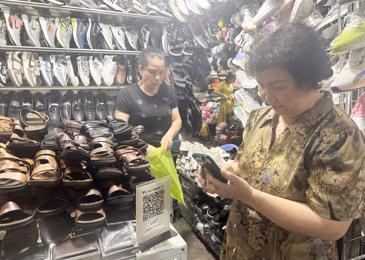 Người dân thanh toán bằng cách quét mã QR code tại chợ Trung tâm Uông Bí (TP Uông Bí).