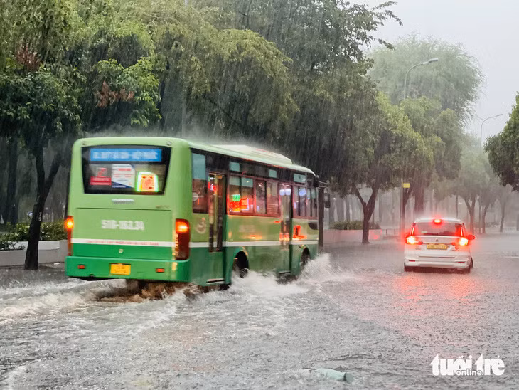Xe buýt chạy qua tạo thành "sóng nước" trên đường Lê Lai, quận 1 - Ảnh: LÊ THÀNH HUY