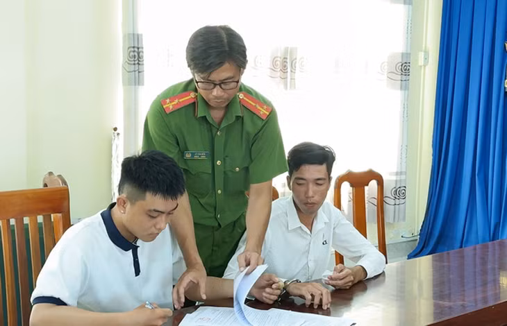 Bị can Hậu và Thanh (trái sang) ký nhận các Quyết định và Lệnh bắt tạm giam. Ảnh: Vũ Tiến