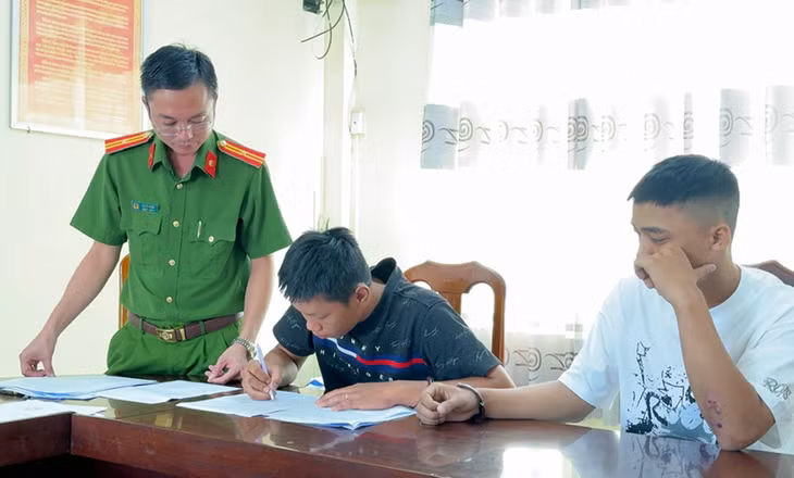 Đối tượng Quí, Di (trái sang) ký nhận các Quyết định và Lệnh bắt tạm giam về hành vi Cố ý gây thương tích. Ảnh: Vũ Tiến