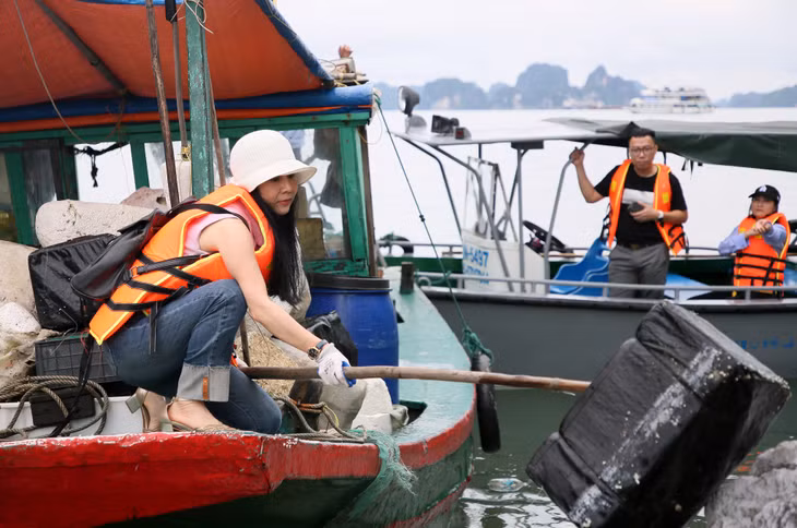 Nhiều phóng viên nữ hết sức tích cực thu gom những tảng phao xốp lớn để đưa lên tàu vận chuyển về bờ.