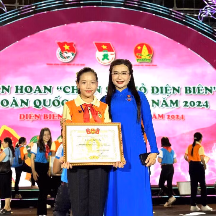 Đinh Thu Trà chụp ảnh lưu niệm cùng Chủ tịch Hội đồng Đội Trung ương trong Liên hoan "Chiến sĩ nhỏ Điện Biên" toàn quốc năm 2024. Ảnh: Nhân vật cung cấp.