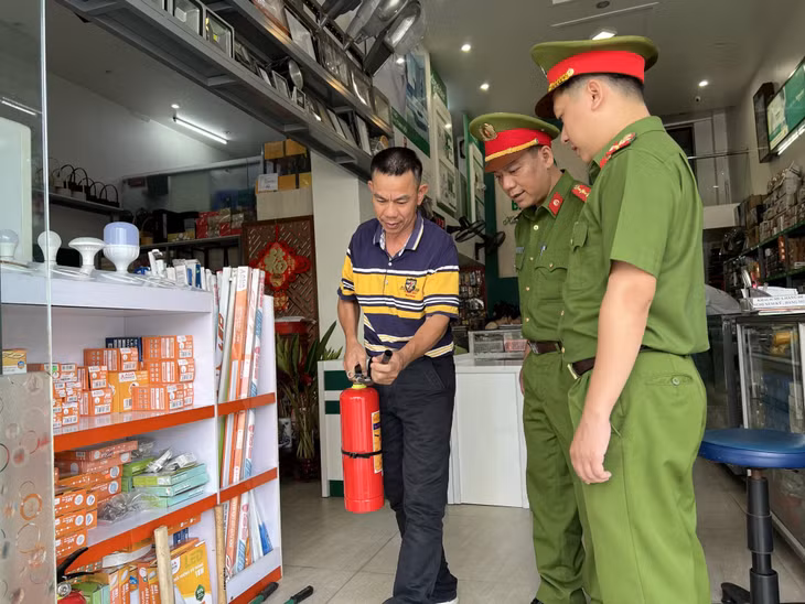 Công an TP Hạ Long tuyên truyền, hướng dẫn người dân sử dụng bình chữa cháy xách tay.