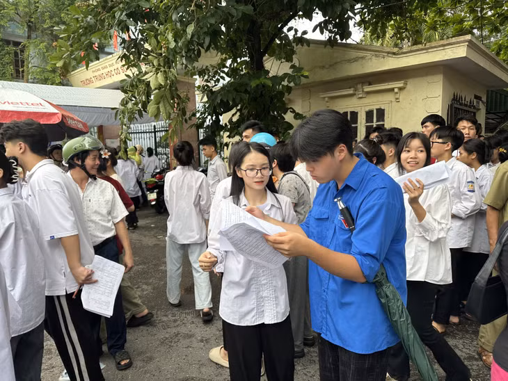 Các thí sinh trao đổi với bạn bè về bài thi của mình sau giờ thi.