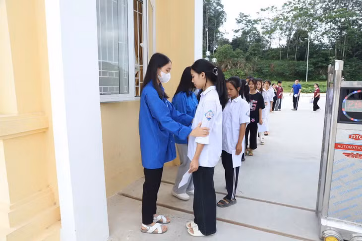Đoàn viên thanh niên huyện Bình Liêu kiểm tra đồ dùng, giữ đồ cho thí sinh trước khi bước vào phòng thi.