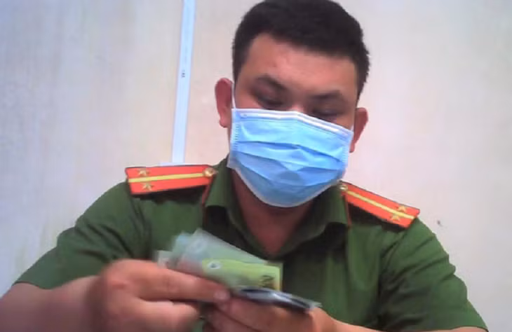 Ông Đại thời điểm thu tiền của người vi phạm ở trụ sở Công an phường Tân An - Ảnh: N.Y