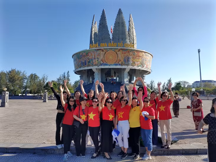 Du khách chụp ảnh check-in tại Cụm Thông tin cổ động biên giới Sa Vĩ.