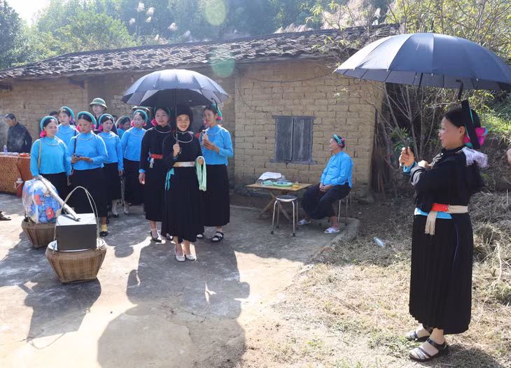 Người đón dâu cầm ô, chờ thầy làm lễ để chuẩn bị đón cô dâu về nhà chồng.