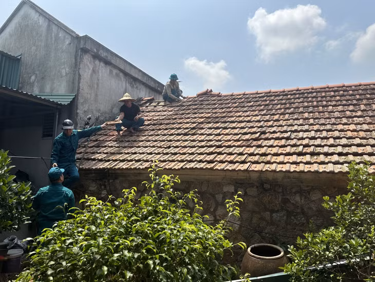 Lực lượng dân quân tự vệ phường Phong Hải, TX Quảng Yên hỗ trợ người dân lợp lại mái.