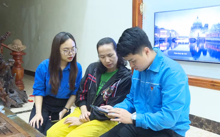 Đoàn viên, thanh niên thị trấn Đầm Hà hướng dẫn người dân sử dụng các tiện ích số trên điện thoại thông minh. Ảnh: Ngọc Trâm
