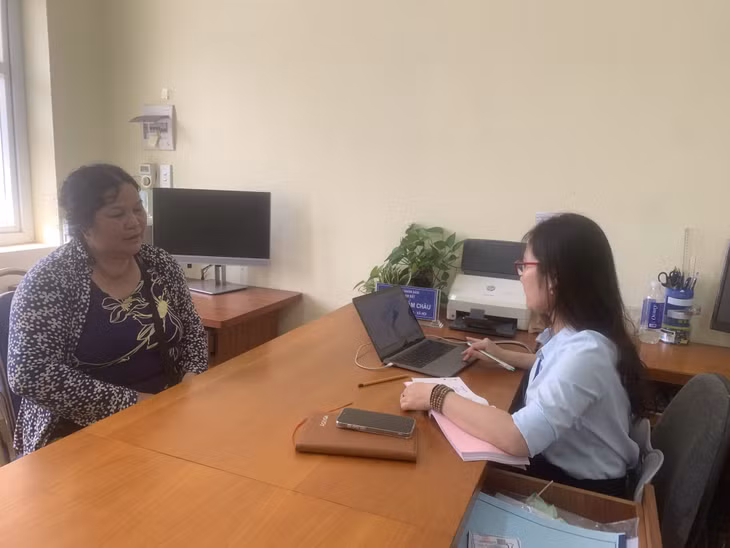 Bà Nguyễn Thị Mây, cư trú tại thôn Khe Ngái đang được cán bộ tuyên truyền, hướng dẫn cách làm thủ tục giấy tờ cho đúng.