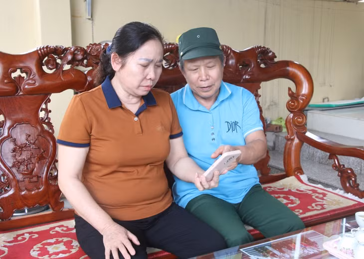 Ông Dương Quang Đông và bà Nguyễn Thị Nhận cùng xem lại những hình ảnh kỷ niệm của con trai.