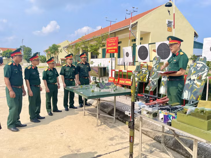 Cán bộ, chiến sĩ Ban CHQS TX Quảng Yên trao đổi về các sáng kiến, cải tiến mô hình học cụ tại đơn vị.