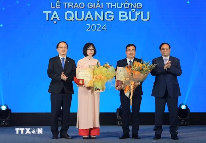 Thủ tướng Phạm Minh Chính và Bộ trưởng Bộ Khoa học và Công nghệ Huỳnh Thành Đạt trao giải thưởng Tạ Quang Bửu cho Phó giáo sư-tiến sỹ Trần Mạnh Trí và Tiến sỹ. Nguyễn Thị Kim Thanh. (Ảnh: Hoàng Hiếu/TTXVN)