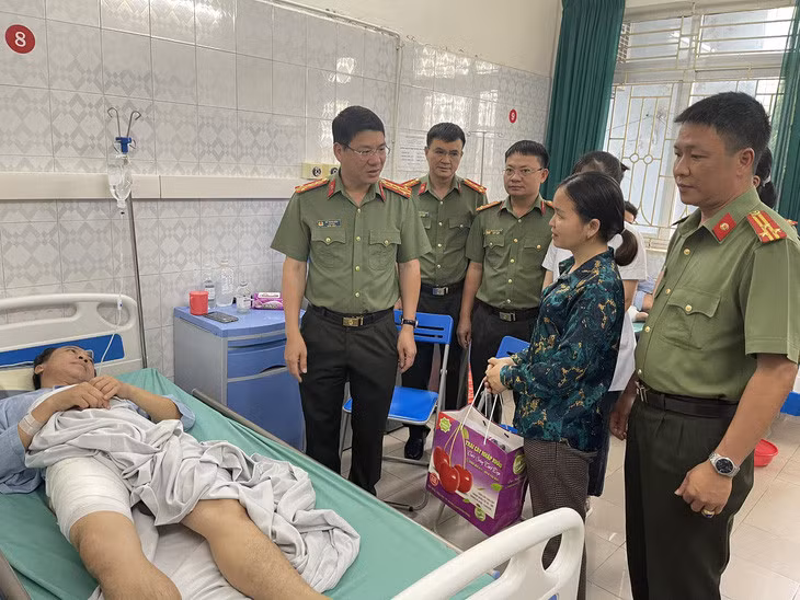 Đại tá Đỗ Thanh Bình - giám đốc Công an tỉnh Hòa Bình - đến thăm hỏi, động viên thiếu tá công an bị thương khi làm nhiệm vụ - Ảnh: Công an cung cấp