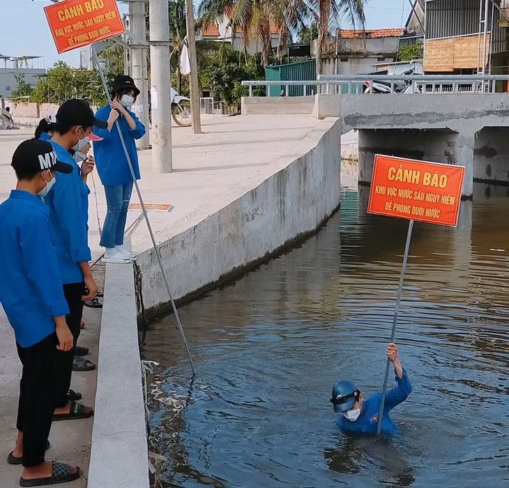ĐVTN TX Quảng Yên cắm biển cảnh báo khu vực nước sâu nguy hiểm. Ảnh: Phạm Tuyết (Trung tâm TT-VH Quảng Yên)
