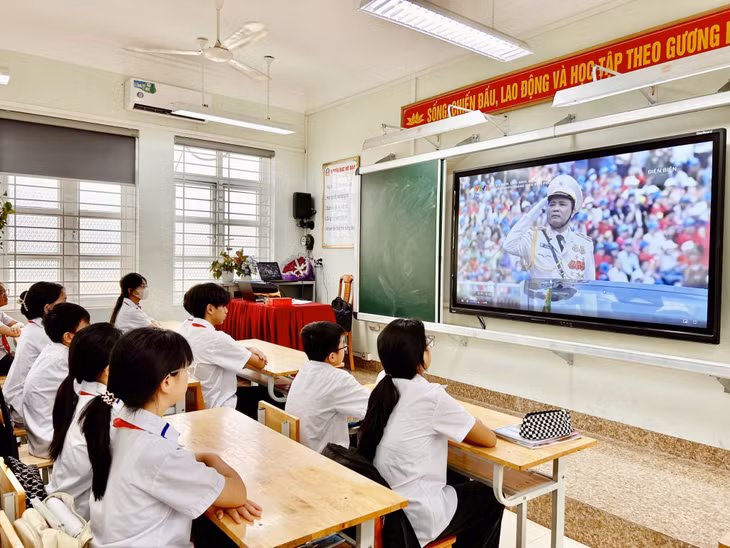 Học sinh Trường THCS Chu Văn An (TP Cẩm Phả) theo dõi Lễ diễu binh diễu hành kỷ niệm 70 năm Chiến thắng Điện Biên Phủ qua màn hình trực tuyến.