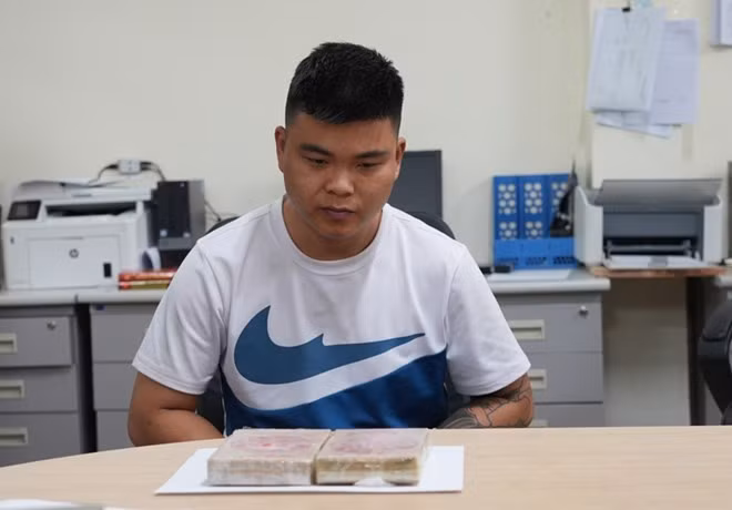 Hứa Thanh Tùng cùng tang vật là 2 bánh heroin. Ảnh: Công an Cao Bằng