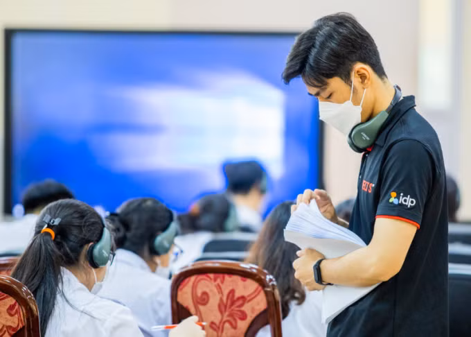 Nhân viên IDP hỗ trợ học sinh thi thử IELTS, tháng 4/2023. Ảnh: IELTS by IDP
