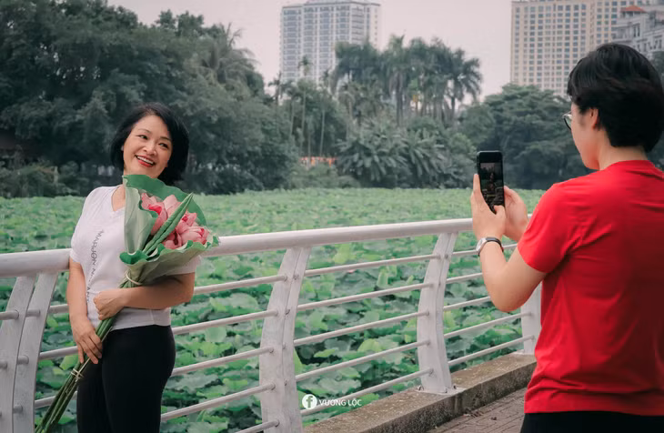 Du khách lưu lại những bức ảnh đẹp bên đầm sen. Ảnh: Vương Lộc