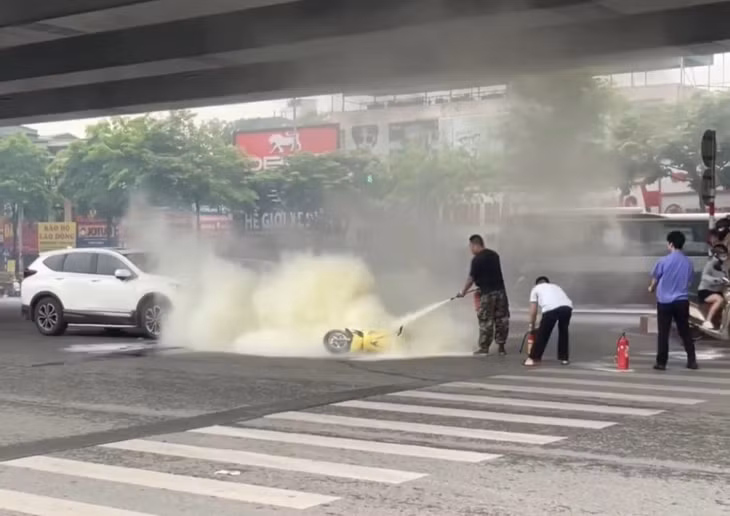 Khoảnh khắc người dân và lực lượng chức năng dập tắt chiếc xe máy bốc cháy.