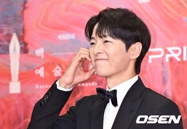 Song Joong Ki tạo dáng trái tim khi đi thảm đỏ Baeksang 2024. Ảnh: Osen.