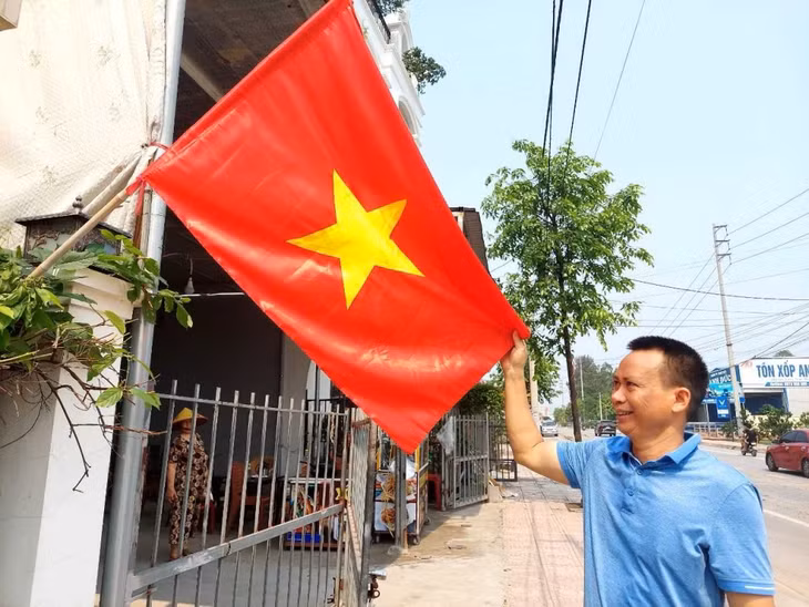 Người dân treo cờ Tổ quốc chào mừng đại hội đại biểu MTTQ các cấp. Ảnh: Trung tâm TT-VH Quảng Yên