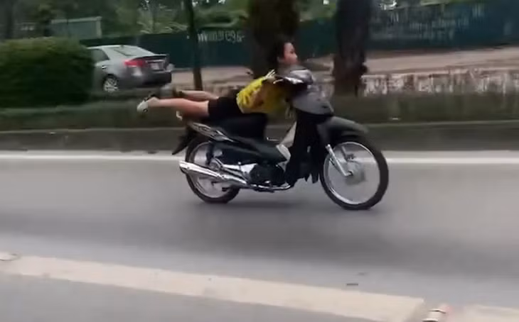 Nam thanh niên nằm trên yên xe lạng lách, đánh võng trên phố ở Hà Nội.