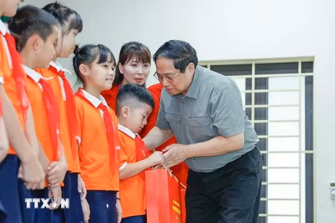Thủ tướng Phạm Minh Chính tặng quà cho trẻ em khuyết tật tại Trung tâm Nuôi dưỡng trẻ khuyết tật Hà Nội. (Ảnh: Dương Giang/TTXVN)