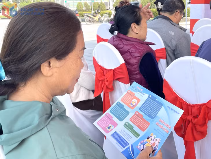 Người dân nghiên cứu tờ rơi tuyên truyền về quyền và nghĩa vụ của người tiêu dùng để nắm rõ quy định pháp luật, lựa chọn và sử dụng hàng hóa an toàn.