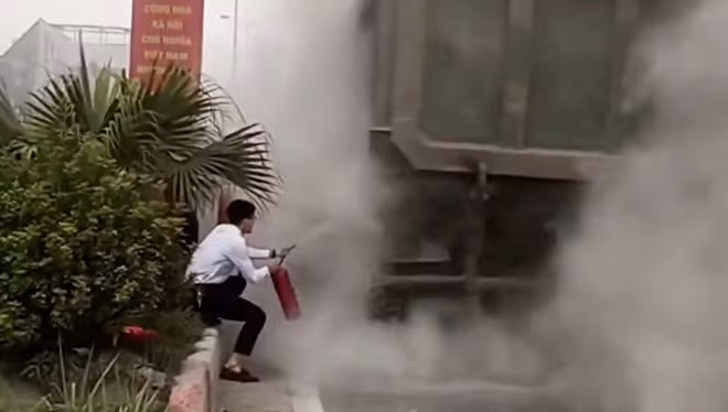 Người dân hỗ trợ dập lửa khi bánh xe tải bốc cháy. Ảnh cắt từ clip